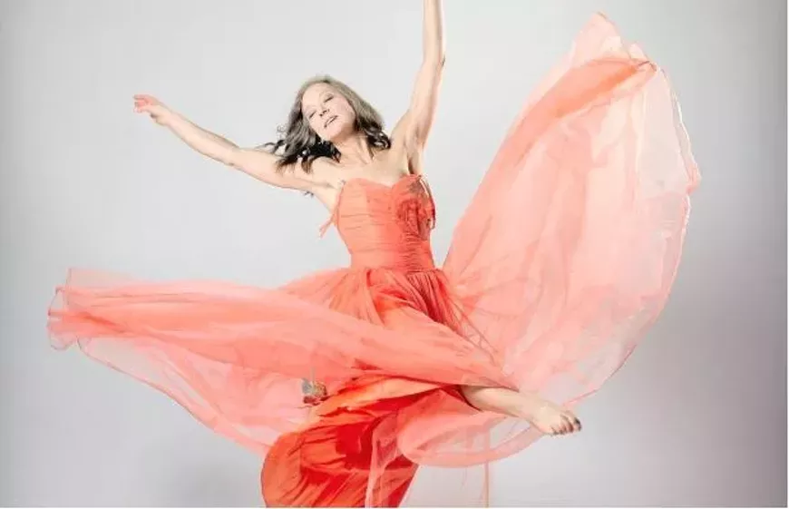 Denise Clarke dancing in a coral coloured dress.