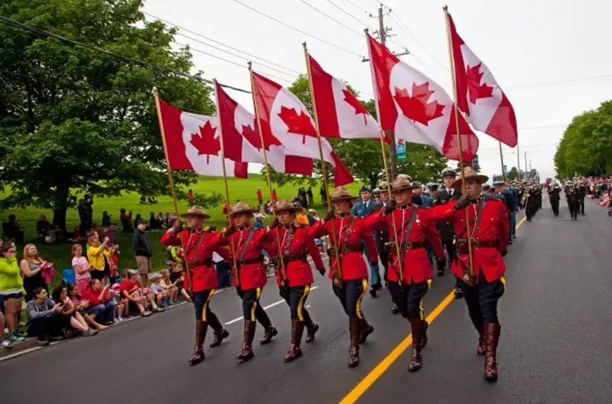 Mounties walk with Canada flags on Citadel Hill.