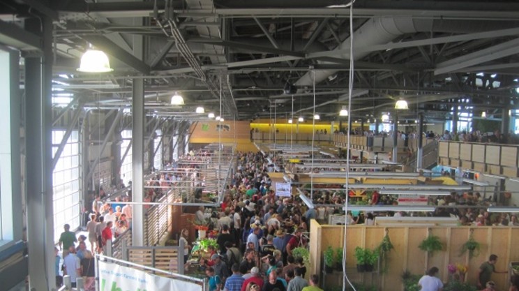 A bustling market scene, showing many people shopping at vendors.