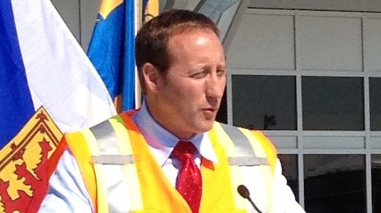 Peter MacKay wears an unattractive bright yellow construction vest at a media event in 2012.