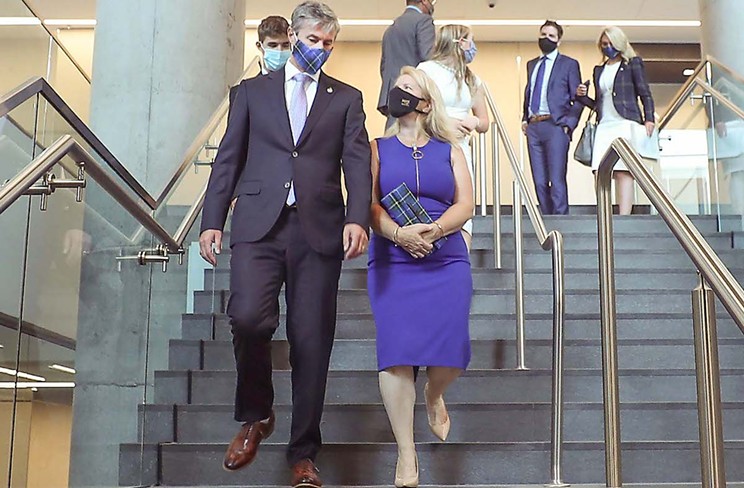 On their way to the premier’s swearing-in ceremony Tuesday, Carol Houston (right foreground, with NS tartan handbag) and her husband Tim (tartan mask) make Nova Scotians wonder who wore it better.