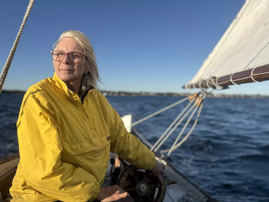 Rita Karston at the helm of the schooner Rencontre, owner Lisa cochrane.